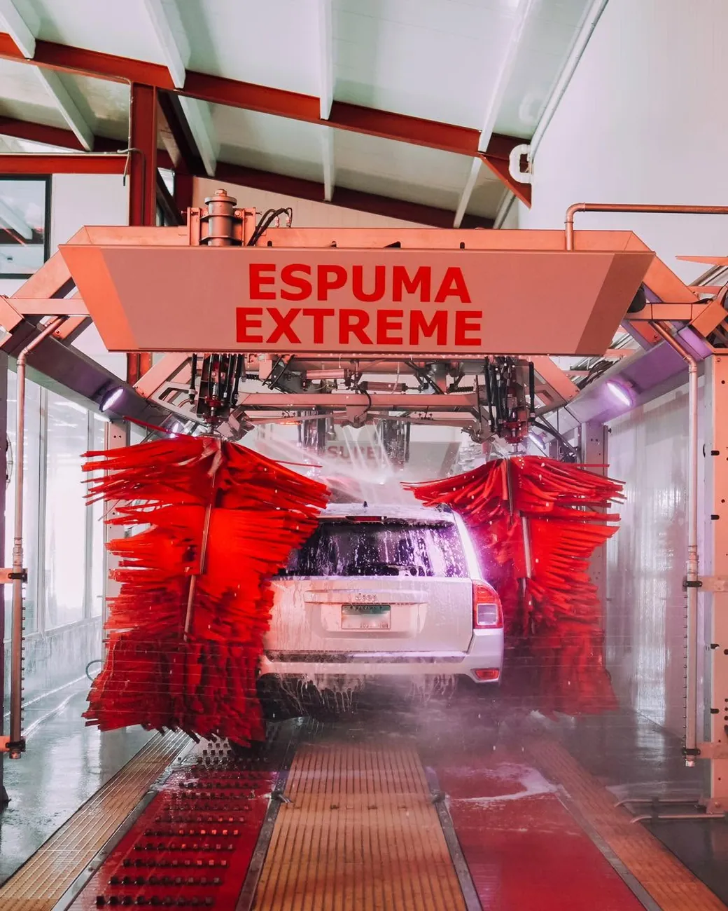 Túnel de lavado Top Car Wash con los cepillos rojos y la Espuma Xtreme en acción
